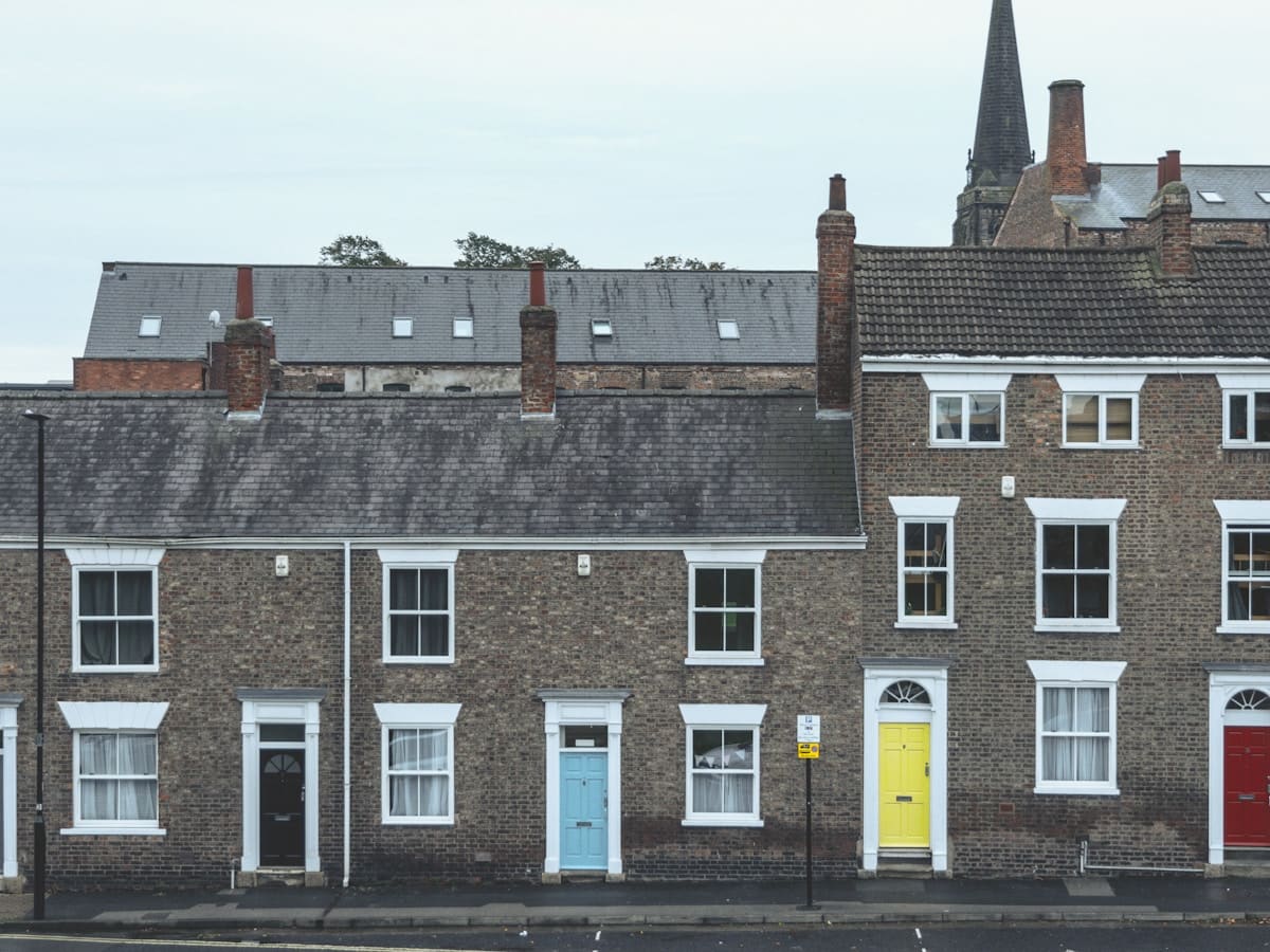 A terrace of brick houses with painted front doors