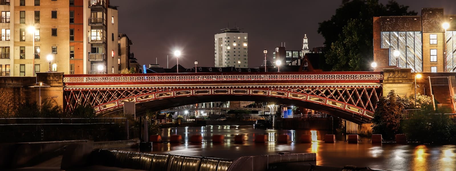 A lit bridge over the River Aire in Leeds at night